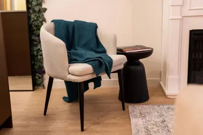 a green blanket on a chair in a living room at Your Own Private Oasis In Victoria in Victoria