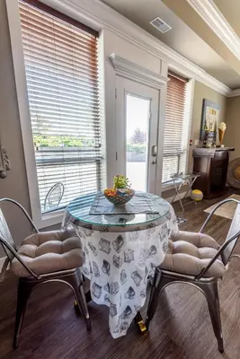 a dining room with a glass table and two chairs at Brookside Inn Boutique Hotel in Abbotsford