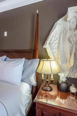 a bedroom with a bed and a table with a lamp at Brookside Inn Boutique Hotel in Abbotsford