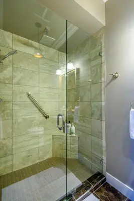 a shower with a glass door in a bathroom at Brookside Inn Boutique Hotel in Abbotsford