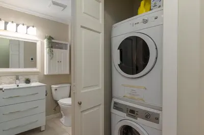 a bathroom with a washer and dryer on the wall at 1BR in Sunpath, Epic Village Location, Private Patio, Pool and Hot Tub, Parking in Whistler