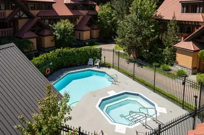an overhead view of a swimming pool with a fence at 1BR in Sunpath, Epic Village Location, Private Patio, Pool and Hot Tub, Parking in Whistler