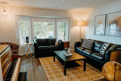 a living room with a couch and a piano at Central Calgary & Nearby Mountain Escape - 4 Beds in Calgary