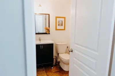a bathroom with a toilet and a sink and a mirror at Central Calgary & Nearby Mountain Escape - 4 Beds in Calgary