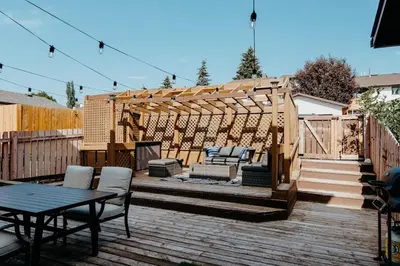a backyard with a wooden deck with a pergola at Central Calgary & Nearby Mountain Escape - 4 Beds in Calgary