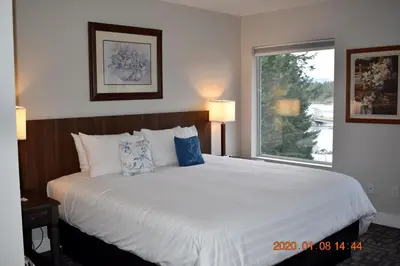 a bedroom with a large white bed with a window at High Pont Resort in Quathiaski Cove