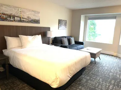 a hotel room with a large bed and a chair at High Pont Resort in Quathiaski Cove