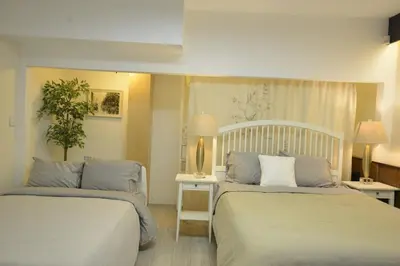 a hotel room with two beds in a room at Bright Spacious 3 BR Garden Suite, 4 Queen beds, Fully equipped, Highly recommended by 229 happy groups in Burnaby