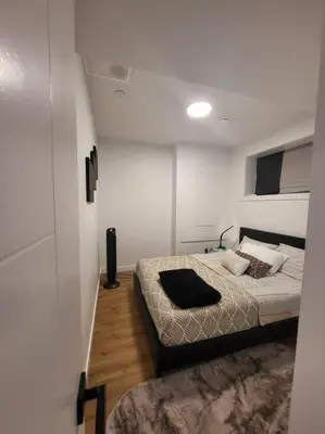 a bedroom with a bed in a small room at Pebbles' Cozy 2Bed Basement Suite - near Downtown in Edmonton