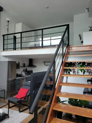 a staircase in a house with a red pillow on a chair at New York Style Loft in Downtown Vancouver-Ideal for World Cup 2026, Sleeps 4 in Vancouver
