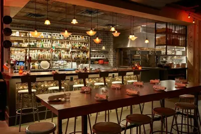 a restaurant with a bar with tables and stools at Fairfield Inn & Suites by Marriott Calgary Downtown in Calgary