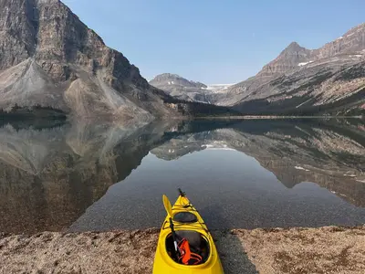 a yellow kayak on the shore of a mountain lake at The Lodge at Bow Lake in Lake Louise