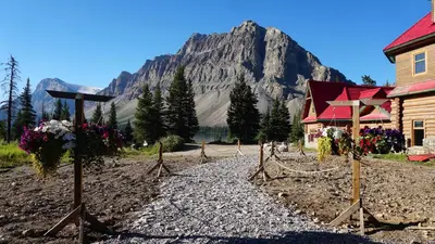 a church and a building with a mountain in the background at The Lodge at Bow Lake in Lake Louise