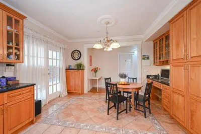 a kitchen with wooden cabinets and a table and chairs at 7 Bedrooms in the Heart of Vancouver in Vancouver
