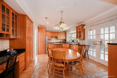 a large kitchen with a wooden table and chairs at 7 Bedrooms in the Heart of Vancouver in Vancouver
