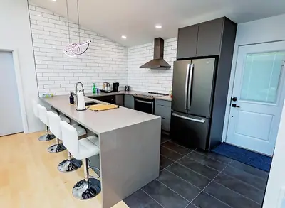 a kitchen with a large counter and a refrigerator at LuxQuarters Bumbleberry Guest House in Kitimat