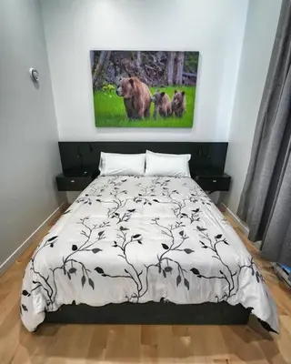 a bedroom with a bed and a painting on the wall at LuxQuarters Huckleberry Suite in Kitimat