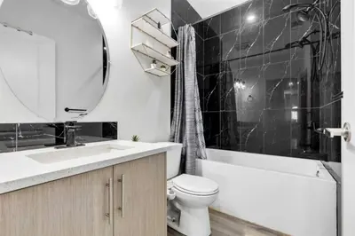 a bathroom with a sink and a toilet and a mirror at Serenity&Luxury Redefined - A waterfront adventure in Airdrie