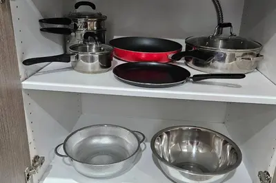 a shelf with pots and pans in a kitchen at Serenity&Luxury Redefined - A waterfront adventure in Airdrie