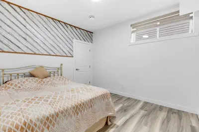 a bedroom with a bed and a window at Serenity&Luxury Redefined - A waterfront adventure in Airdrie