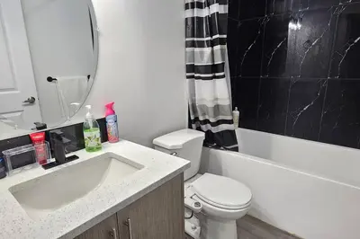 a bathroom with a sink and a toilet and a bath tub at Serenity&Luxury Redefined - A waterfront adventure in Airdrie