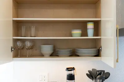 a kitchen cabinet with plates and cups and glasses at Riley Park-Modern 4 Bedroom Home, Central location in Vancouver