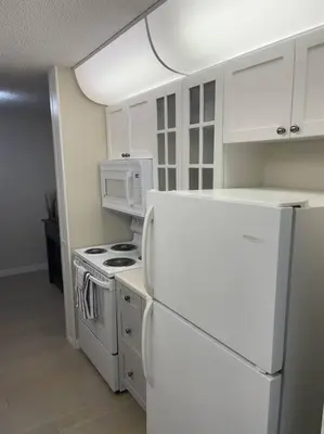 a kitchen with white appliances and a white refrigerator at Chris Cozy Condo Commonwealth #107 Edmonton in Edmonton