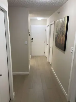 a hallway with white walls and a hallway with a hallwayngthngthngthngthngth at Chris Cozy Condo Commonwealth #107 Edmonton in Edmonton