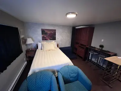 a bedroom with a bed and a desk with a chair at Frankies Westshore Hideaway in Victoria
