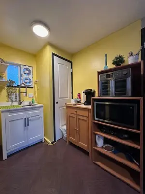 a kitchen with yellow walls and a microwave oven at Frankies Westshore Hideaway in Victoria