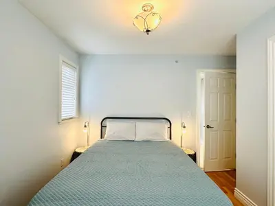 a bedroom with a bed with a blue bedspread at Spacious 5BR 3BA Guest Villa - 10 Min to DT - Pet Friendly, Free Parking in Vancouver