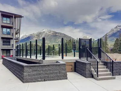 a building with a staircase and mountains in the background at Spring Creek Luxury - managed by Little Sister Getaways in Canmore