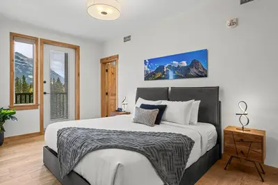 a bedroom with a large bed and a window at Spring Creek Luxury - managed by Little Sister Getaways in Canmore
