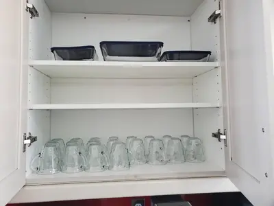 a cabinet filled with glass jars sitting on shelves at 33 Executive Home, Ac, Airport in Calgary