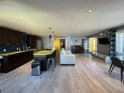 a large kitchen and living room with wooden floors at Little Holiday Home in Yellowknife
