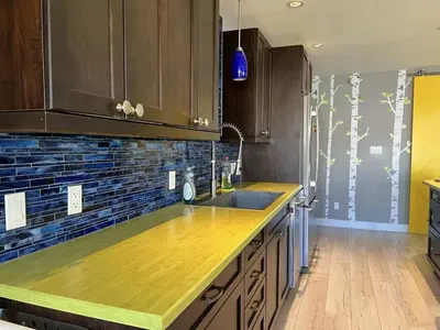 a kitchen with wooden cabinets and a counter top at Little Holiday Home in Yellowknife