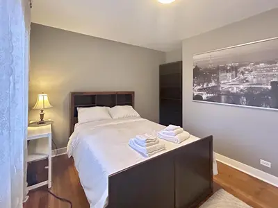 a bedroom with a bed with towels on it at Airport-YVR GuestHouse in Richmond