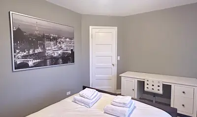 a bedroom with a bed with a picture on the wall at Airport-YVR GuestHouse in Richmond