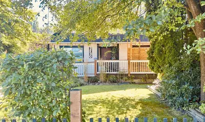a house with a fence in front of it at Airport-YVR GuestHouse in Richmond