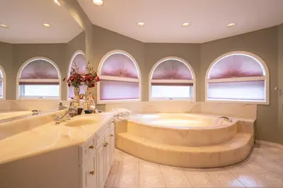 a bathroom with a tub and two sinks and windows at Cornerstone Bed and Breakfast in Revelstoke