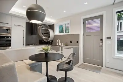 a kitchen with a table and a couch at Designer 2BR in Downtown Steps from Sunset Beach in Vancouver