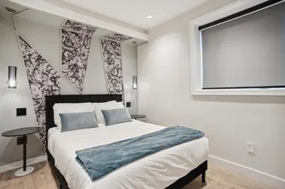 a bedroom with a bed and a flat screen tv at Designer 2BR in Downtown Steps from Sunset Beach in Vancouver