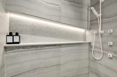 a bathroom with a shower with a glass door at Designer 2BR in Downtown Steps from Sunset Beach in Vancouver