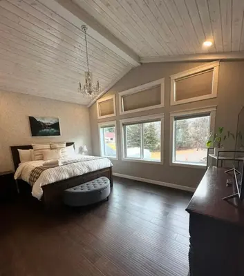 a large bedroom with a bed and large windows at Caribou Lodge in Terrace