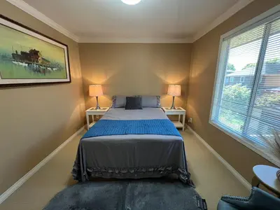 a bedroom with a bed and two lamps and a window at Terra Nova - Private property in Richmond