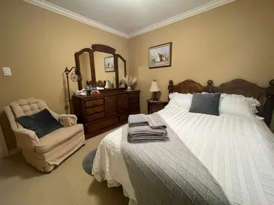 a bedroom with a bed and a chair and a mirror at Terra Nova - Private property in Richmond