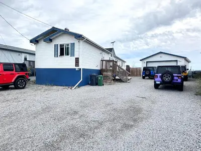 a house with two trucks parked in front of it at EC Lodging in Yellowknife