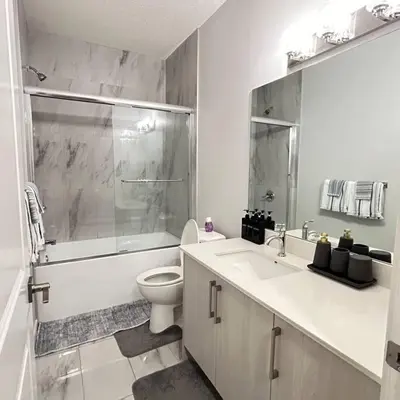a bathroom with a toilet and a sink and a shower at Comfortable and centrally located guest suite in Calgary