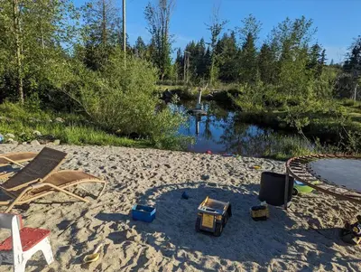 a sandy beach with toys in the sand next to a river at Mushroom theme cabin on 33 Acre Farm in Brew Bay