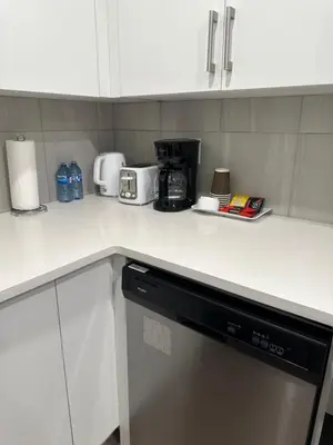 a kitchen with white cabinets and a dishwasher at A Luxurious Cozy Place in Calgary